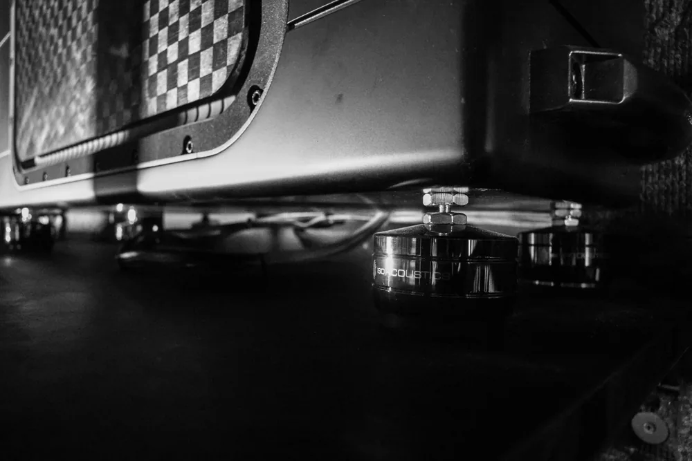 Close detail of IsoAcoustics isolation feet under a subwoofer