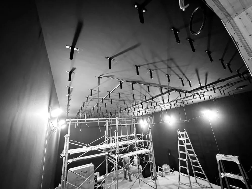 The ceiling of the inner room during installation, with fixings and suspension points in rows and scaffolding below