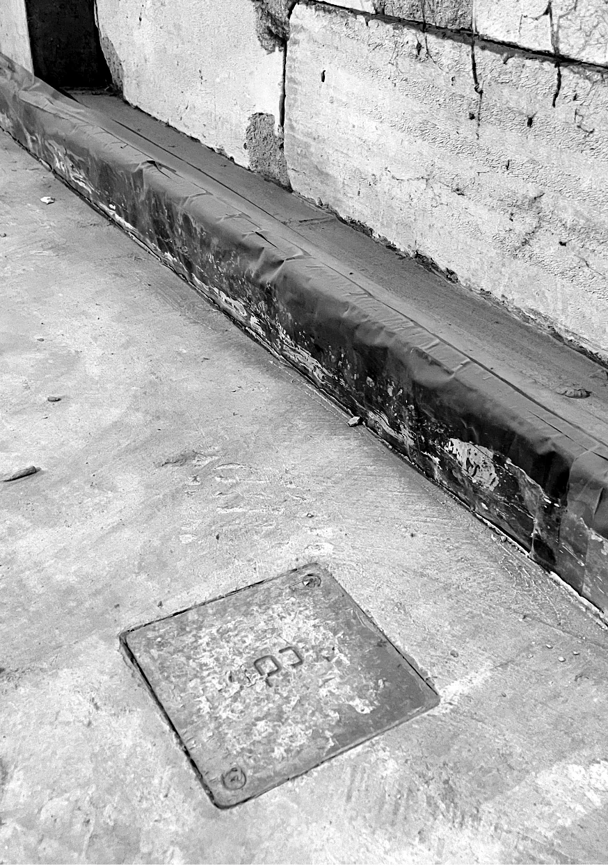 The cover of a CDM Stravitec jack-up box set into the cured concrete slab, close to the wall