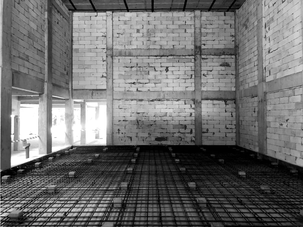 The bare structural shell with CDM Stravitec jack-up boxes set out in a grid among the steel reinforcement, before the slab was poured