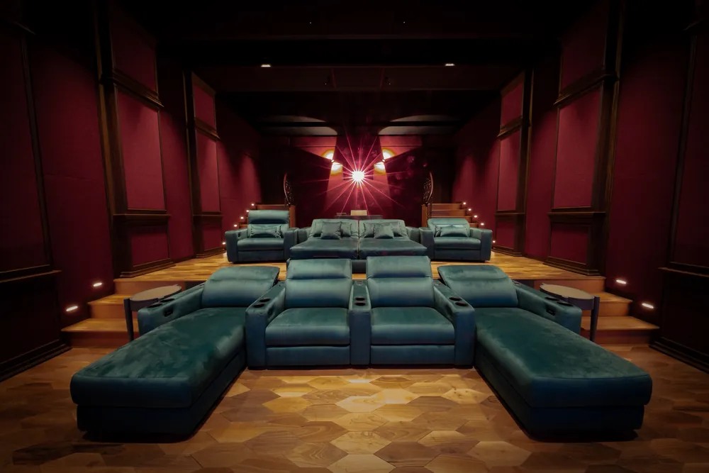 Looking from the screen wall towards the rear of the cinema, two raised rows of seating with wall lighting