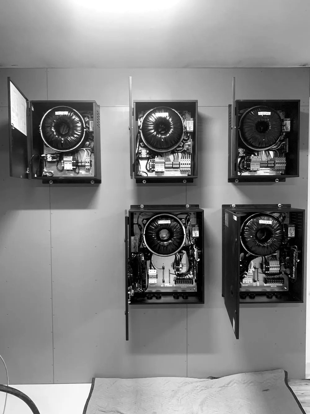 Five Torus Power wall-mounted isolation transformers with their covers open, showing the toroidal transformers inside